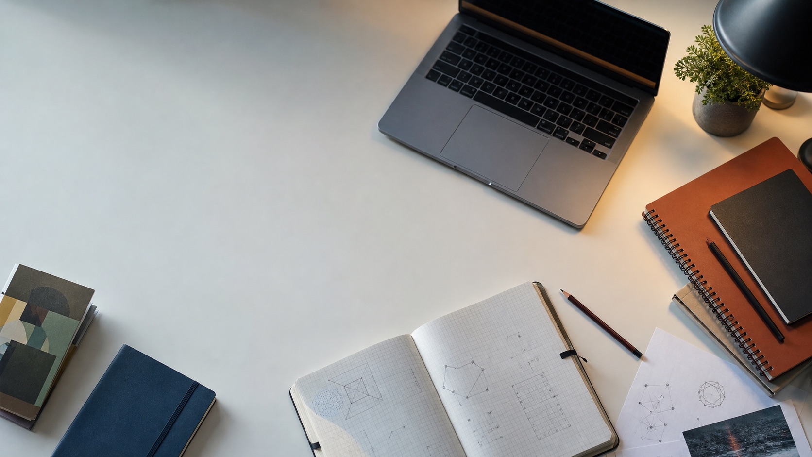A quiet desk with notebooks, diagrams, and a laptop.